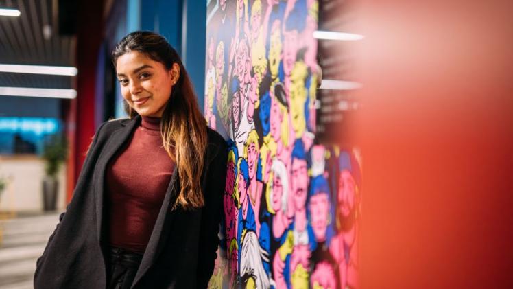 female student standing leaning against wall